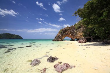 Yazın Lipe Adası yakınlarındaki Koh Khai 'de Satun, Tayland' da doğal taş kemeri. Tayland ya da Siyam 'ın güneyindeki Tarutao Ulusal Parkı' nda ünlü bir seyahat merkezi ya da yaz tatilcisi..