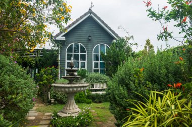 Çeşme ve güzel bahçe İngiltere tarzı modern ahşap evin önünde..