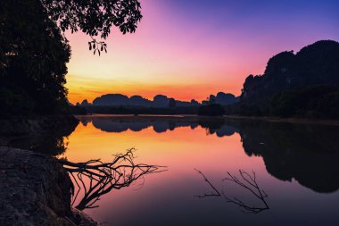 Güzel göl ve kireçtaşı karst dağları şafakta alacakaranlık gökyüzü ve su yansıması, Nong Thale, Krabi, Tayland. Siyam 'ın tropikal ülkesinde ünlü seyahat merkezi veya tatilci.