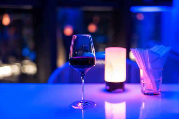 Szklanka Czerwonego Wina Stole Barze Rozmytym Kolorowym Bokeh Światła Nocy — Zdjęcie stockowe