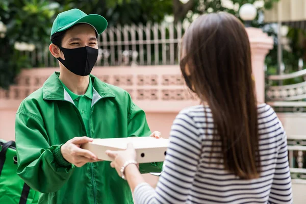 Consegna Pizza Corriere Sorridente Fattorino Uniforme Verde Maschera Viso Dando — Foto Stock