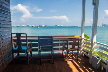 Tahta masa ve yazın Pattaya, Chonburi, Tayland 'da deniz kenarındaki kafe sandalyeleri. Ev yurdu ya da sahil kenarındaki otel..