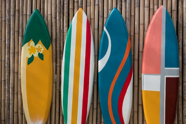 竹木墙上一排排色彩艳丽的彩绘冲浪板 — 图库照片