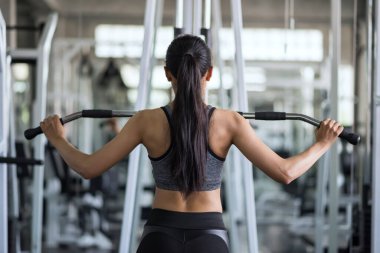 Formda Asyalı genç kadın egzersizi spor salonunda pompalayarak. Orta yaşlı kadınlar için vücut geliştirme ve sağlıklı yaşam tarzı.