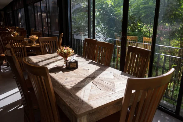 Restoran ahşap masa. Sabahları suni çimen ve çiçekli. Dışarısı yeşil doğal..