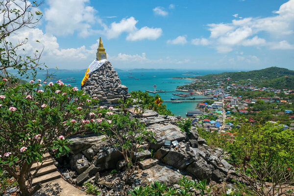 Golden pagoda on hill summit with top view of sea and city at Juthathit temple, Si Chang island, Siracha, Chonburi, Thailand. Famous travel destination in tropical country, Siam.