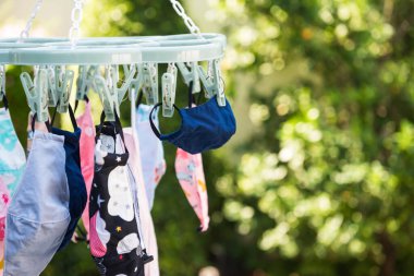 Fabric face masks hang to dry by sun light after washing to reuse to prevent covid-19 pandemic.