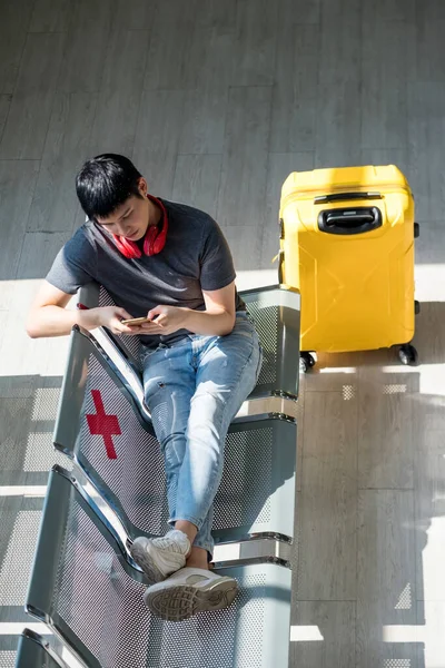 Widok Góry Młody Turysta Siedzieć Lotnisku Terminal Krzesło Żółtym Bagażem — Zdjęcie stockowe