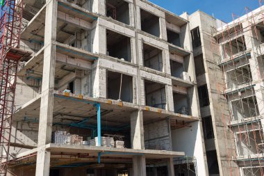 Construction site background. Concrete on multi-storey buildings with scaffold and tower crane. Industrial concept.