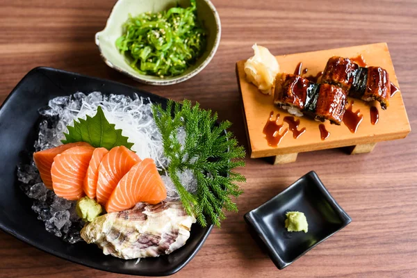 在木制桌子上俯瞰鲑鱼生鱼片 海藻和鳗鱼寿司 餐馆里有名的日本菜 — 图库照片