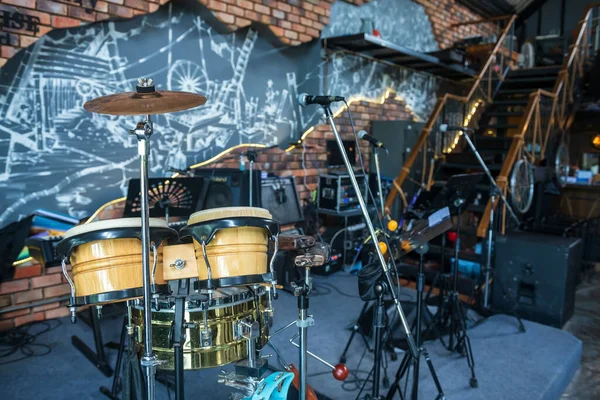 drum kit with microphone and electric instruments placed on a stage ready for a performance concert at restaurant