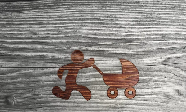 Símbolo de buggy bebé aislado en un fondo de madera Imagen De Stock