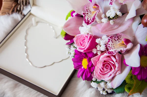 Regalo di giorno di San Valentino - Collana d'oro in una posizione di cuore e fiori Fotografia Stock