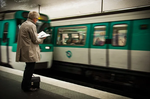 bir adam bir metro metro beklerken Gazeteler okuma