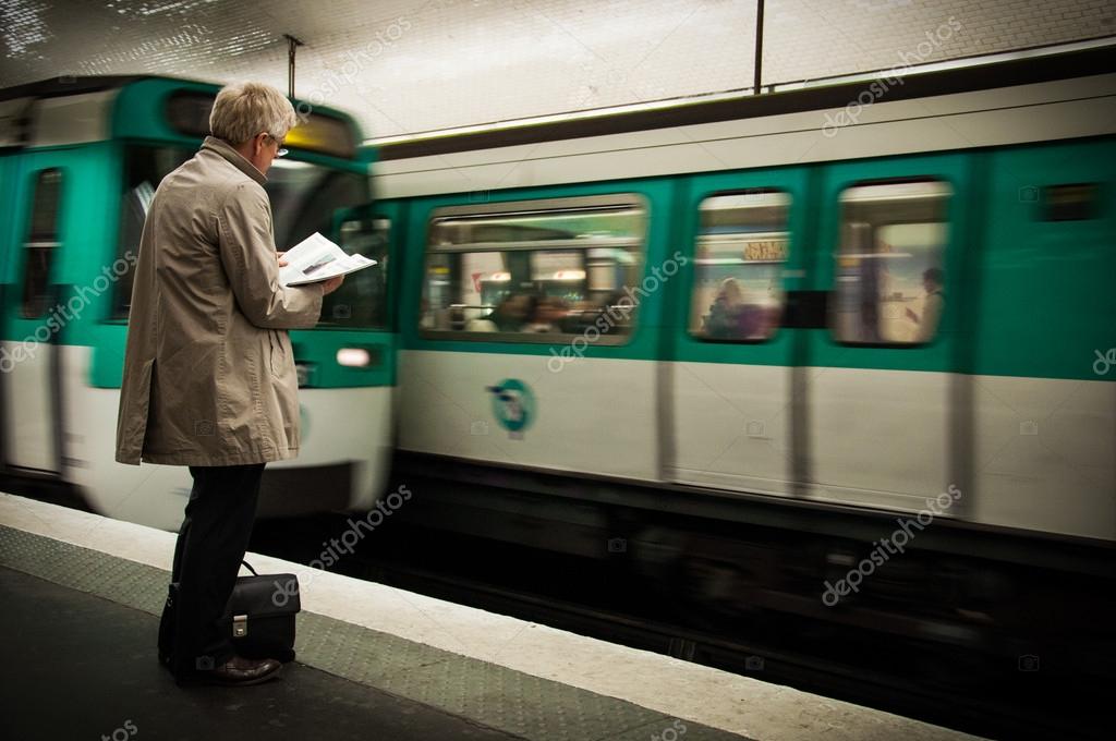 A man reading newspapers while waiting the metro in a subway – Stock ...