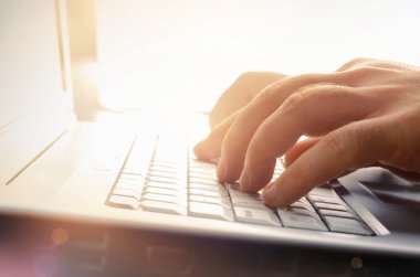 Man's hands typing on laptop keyboard clipart