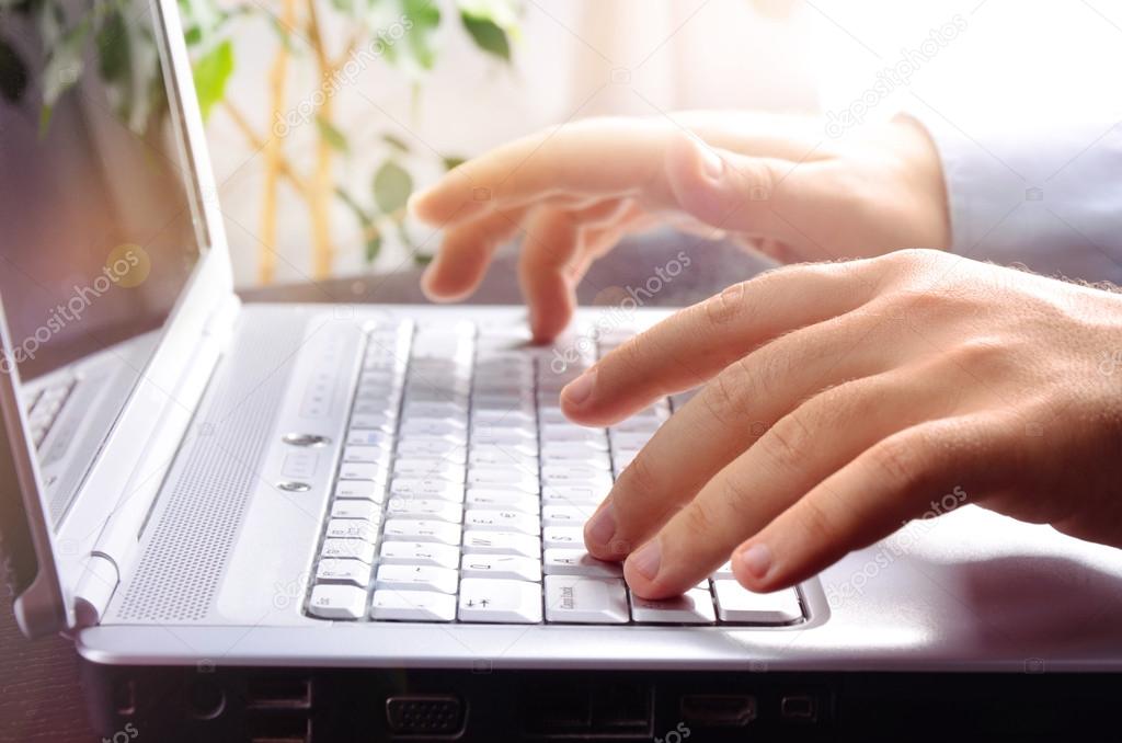 Businessman typing on laptop keyboard