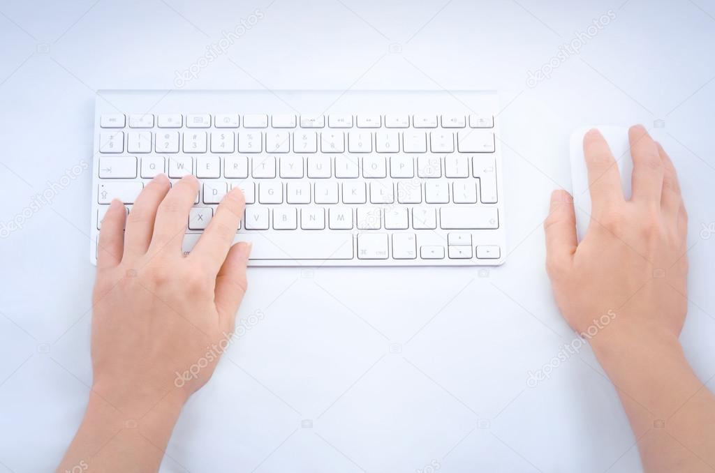 Woman's hands using mouse and keyboard
