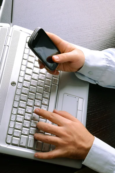 Businessman using laptop and mobile phone — Stock Photo, Image