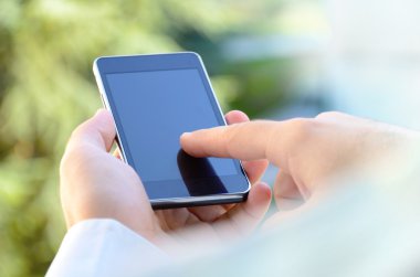 açık mobil akıllı telefon kullanan genç adam omuz görünümü üzerinde arka plan bulanık.