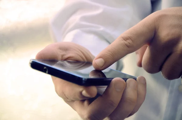 De mannelijke handen een smartphone gebruiken — Stockfoto