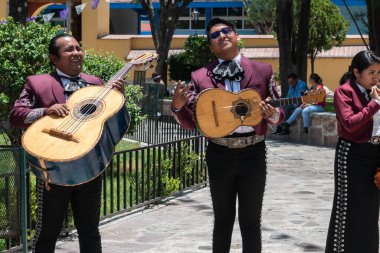 TLACOLULA, OAXACA, MEXICO - 23 Mayıs 2022: Parroquia Santa Maria de la Asuncion dışındaki kameraya poz veren Mariachi üyeleri, Tlacolula, Oaxaca, Meksika
