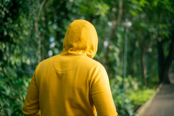 Yellow Hooded Man Walking Public Park 免版税图库图片