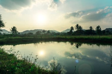 landscape picture of the sun setting over a lake and mountains