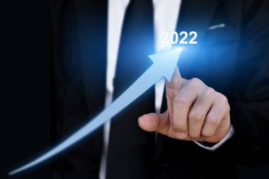 2022 yıllık iş büyüme konsepti. İşadamı ok grafiğini işaret ederek kurumsal gelecek büyütme planı.