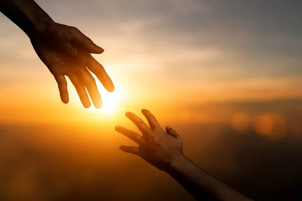 手を差し伸べ 手を差し伸べ 希望を与え お互いにぼやけた日没の空の背景をサポートするシルエット 国際平和の日の概念と友情を発展させ — ストック写真
