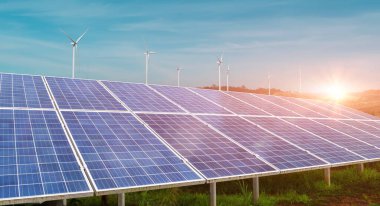 Güneş paneli ve rüzgar türbini alanı günbatımında gökyüzü arka planında. Fotovoltaik, alternatif elektrik kaynağı. Sürdürülebilir kaynaklar. Alternatif enerji konsepti.