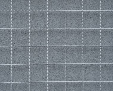 Metal bir ızgara ve arkasında gri bir duvar.