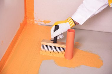 builder brush applied waterproofing on the floor of the bathroom clipart