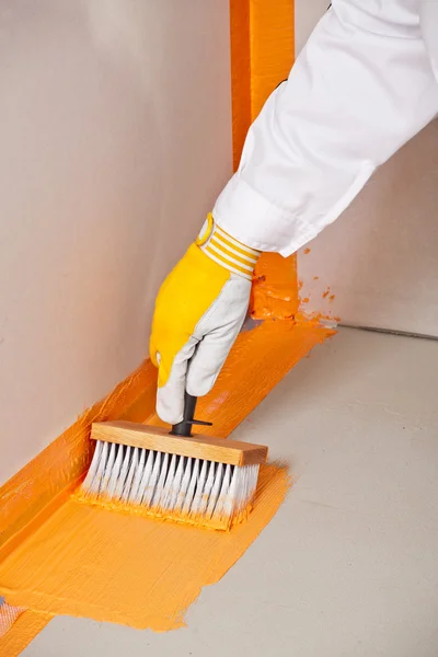 Builder brush applied waterproofing on the floor of the bathroom — Stock Photo, Image