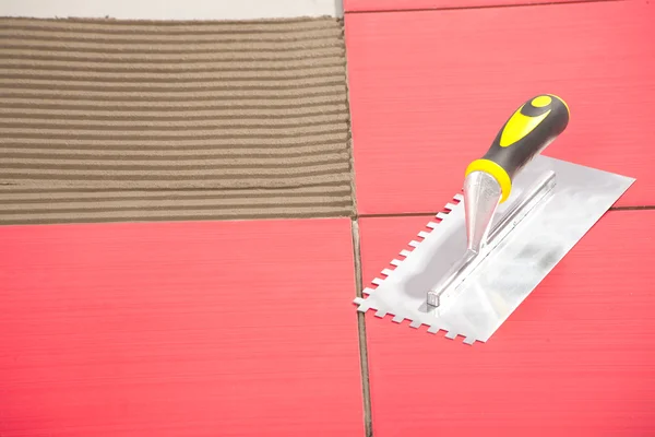 Notched trowel on red tiles — Stock Photo, Image