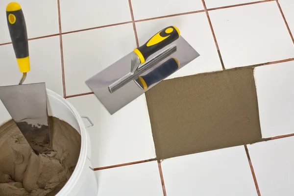 Repaired old white tiles floor with Trowel and tile adhesive — Stock Photo, Image