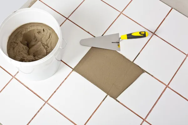 Trowel and old white tiles with tile adhesive — Stock Photo, Image