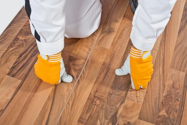 Werknemer analyseren houten vloer voor scheuren — Stockfoto