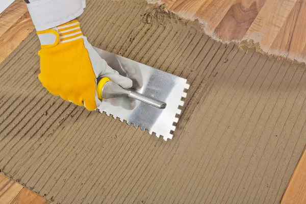 Adesivo piastrelle applicato lavoratore sul vecchio pavimento di legno — Foto Stock