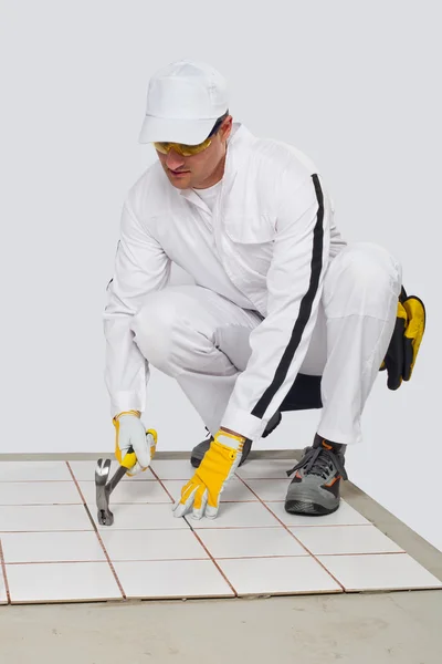 Worker checks old tiles base with hammer — Stock Photo, Image