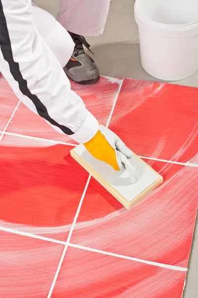 Trabajador limpio con esponja paleta de azulejos juntas lechada — Foto de Stock