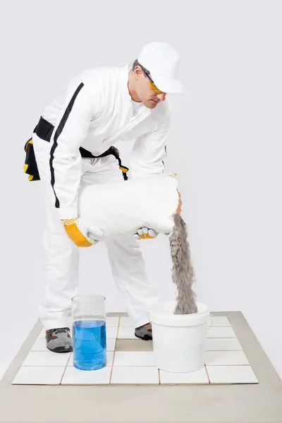 Worker mix tile adhesive bucket of water white tiles — Stock Photo, Image