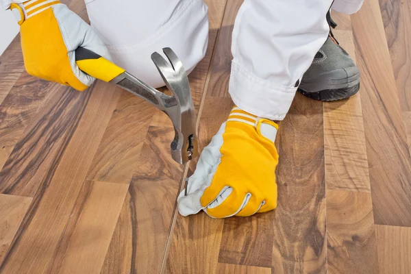 Ouvrier cloué vieilles fissures de plancher en bois — Photo