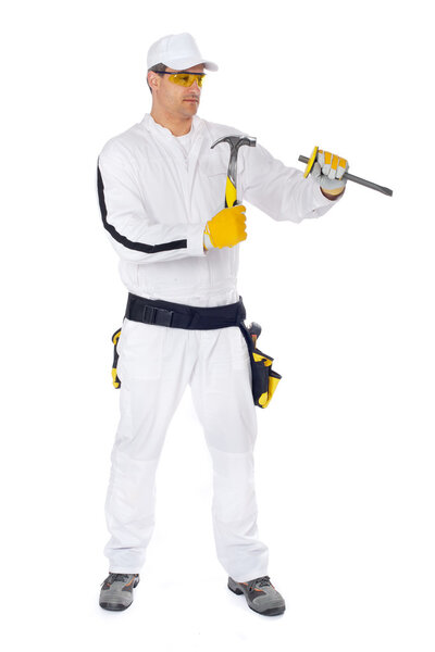 Рабочие в белых комбинезонах, работающие с молотком и зубилом
