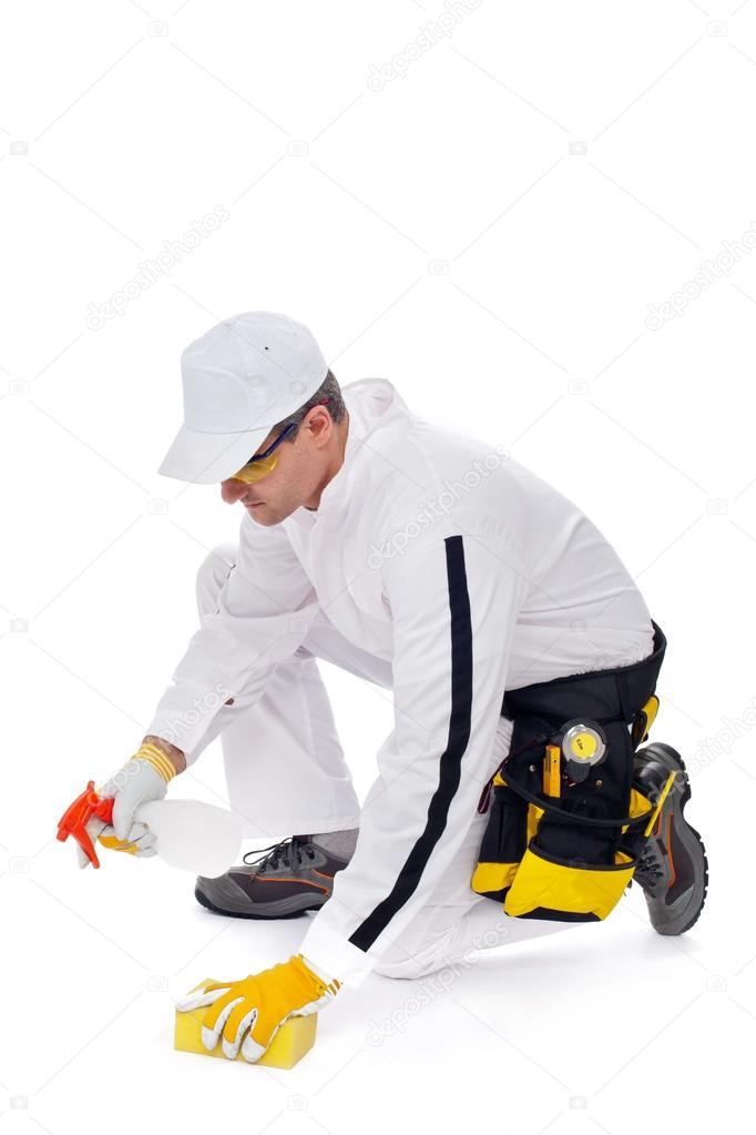 worker cleans the floor with a sponge and spray