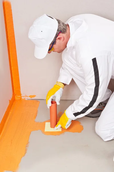 Fontanero aplicado manguito de impermeabilización en el suelo del baño —  Fotos de Stock