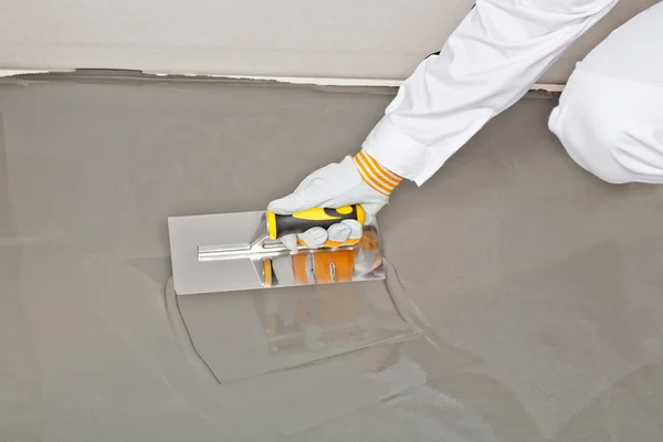 Spreading self leveling compound with trowel — Stock Photo, Image