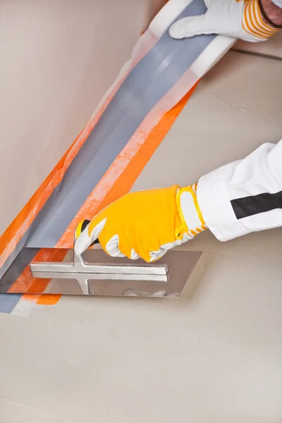 Worker apply hydro insulation tape around the wall and floor — Stock Photo, Image