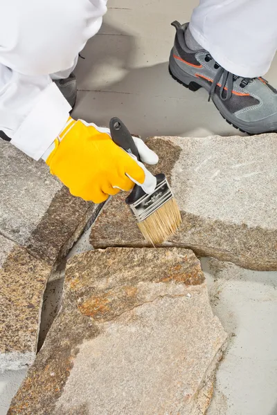 Worker brush primer grout of stones joint — Stock Photo, Image