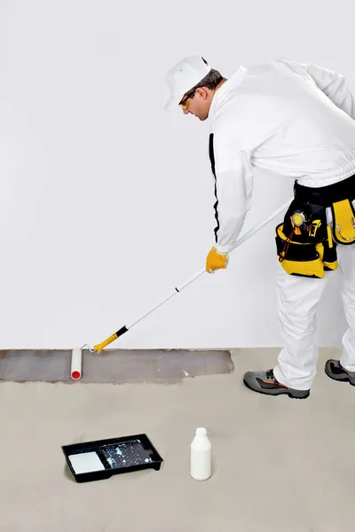 Tinta de trabalhador com piso de concreto primário para impermeabilização — Fotografia de Stock